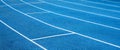 Blue running treadmill track with lane in-stadium outdoors.banner image