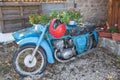 Blue Russian motorcycle, Soviet motorcycle Izh Jupiter with helmet, filled with blooming flowers decoration