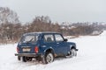Blue Russian off-road car Lada Niva 4x4 VAZ 2121 / 21214 parked on the snow field.