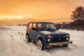 Blue Russian off-road car Lada Niva 4x4 VAZ 2121/21214 parked on the snow field.