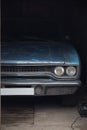 Blue rusty dusty american musclecar Plymouth Belvedere 1970 in the garage. Head lights