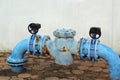 Blue rusty metal industrial water pipes with a valve. Royalty Free Stock Photo