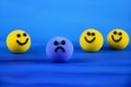 Blue sad ball and happy yellow balls stock images