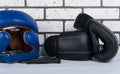 Blue safety helmet, jump ropes and boxing gloves, against a light brick wall Royalty Free Stock Photo