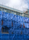Blue safety netting on scaffolding on building site in dutch town of utrecht in holland Royalty Free Stock Photo