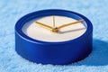 Blue sand clock with golden hands on textured surface captures time's essence Royalty Free Stock Photo
