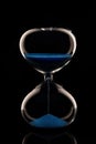 Blue sand hourglass on black background Royalty Free Stock Photo