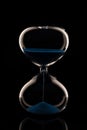 Blue sand hourglass on black background Royalty Free Stock Photo