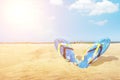 Blue sandal flip flop on the white sand beach with blue sea and sky background in summer vacations copy space