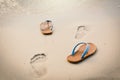 Blue sandal with footprint on the beach concept time to travel Royalty Free Stock Photo