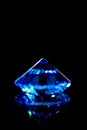 Blue sapphire in front of black background, brilliant cut