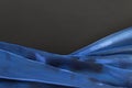 Blue satin fabric folds on black background with copy blank space Royalty Free Stock Photo