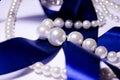 Blue satin ribbon with pearl jewelry. Luxurious decoration. For jewelry sites, blogs about fashion, style, jewelry. Snow-white