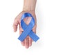 Blue satin ribbon on a woman's palm, isolated on a white background. Cancer awareness symbol, men's health. copy space Royalty Free Stock Photo