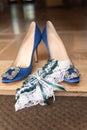 Blue satin shoes and a white garter. Royalty Free Stock Photo