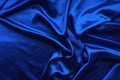 Blue satin, silky fabric, wave, draperies. Beautiful textile backdrop. Close-up. Top view