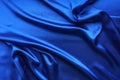 Blue satin, silky fabric, wave, draperies. Beautiful textile backdrop. Close-up. Top view