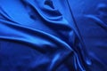 Blue satin, silky fabric, wave, draperies. Beautiful textile backdrop. Close-up. Top view