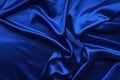 Blue satin, silky fabric, wave, draperies. Beautiful textile backdrop. Close-up. Top view