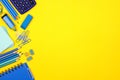 Blue school supplies side border over a yellow background Royalty Free Stock Photo