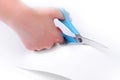 Blue scissors cutting white paper. Royalty Free Stock Photo