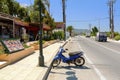 Blue scooter bike is staying parked near traditional Greek tavern on Rhodes island