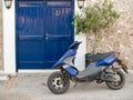 Blue scooter by a blue door