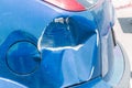 Blue scratched car with damaged paint in crash accident or parking lot and dented damage of metal body from collision Royalty Free Stock Photo