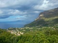 Blue and blue sea, city, rocks under the sky with clouds and fancy shadows on the mountain, Maratea, Basilicata, Italy