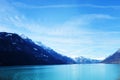 Blue sea and mountains with snow on the tops. Landscape with blue gradient color. Blurred background