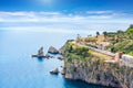 Blue sea and rocky coast at Cape Taormina. Taormina located in Metropolitan City of Messina, on east coast of island of Sicily,