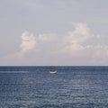 Blue Sea sky cumulus cloud landscape view background. Calm water alone fishing boat. Destination aim progress concept Royalty Free Stock Photo