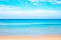 Blue sea with a strip of sandy beach and blue sky. In the background, a child enters the water. Seascape on a sunny day Royalty Free Stock Photo