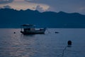 Blue sea sunset, evening - pastel pink sky, clouds, blue foggy mountains on horizon, calm smooth water with breeze, floated. Royalty Free Stock Photo