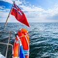 Blue sea. View from deck of yacht sailboat british flag lifebuoy. Travel.