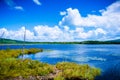 Blue sea water, the coast of the green lawn, the mountains in the distance, the green plants on the hills Royalty Free Stock Photo