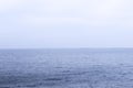 Blue sea water turns into a blue sky, foggy