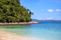 Blue sea water and white beach on sunny day. Tropical island paradise photo. Green forest jungle near seashore Royalty Free Stock Photo