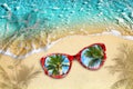 Blue sea wave, yellow sand beach, turquoise ocean water, red sunglasses, reflection blue sky, green palm trees, summer holidays