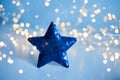 Blue sequins Christmas star with blurred gold lights background, copy space Royalty Free Stock Photo