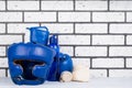 Blue set of helmet and boxing gloves for sports on the background of a brick wall, on the right there is a place for inscription