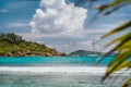 Blue shallow lagoon, white ocean wave and lonely yacht boat at Anse Cocos beach, La Digue island, Seychelles. Luxury