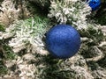 Blue shiny Christmas ball on the tree. Close-up. Festive Christmas toys. Royalty Free Stock Photo