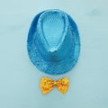 Blue shiny sequined party Hat next to yellow bow over wooden background. Purim celebration concept Royalty Free Stock Photo