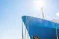 Blue ship`s nose on a blue sky background. Ship`s ropes. Bright sun above the deck. Royalty Free Stock Photo