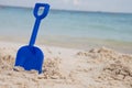 Blue shovel in sand