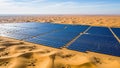 Vast Solar Panel Array Installed in a Desert Landscape with Sand Dunes Under a Clear Blue Sky Royalty Free Stock Photo