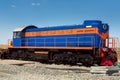 Blue shunting diesel locomotive with an orange stripe.