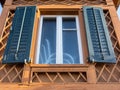 Blue shutters around the window on cottage with special wooden details Royalty Free Stock Photo