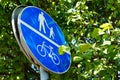 Blue sign featuring an elderly man, child and a bicycle surrounded by trees and leaves Royalty Free Stock Photo